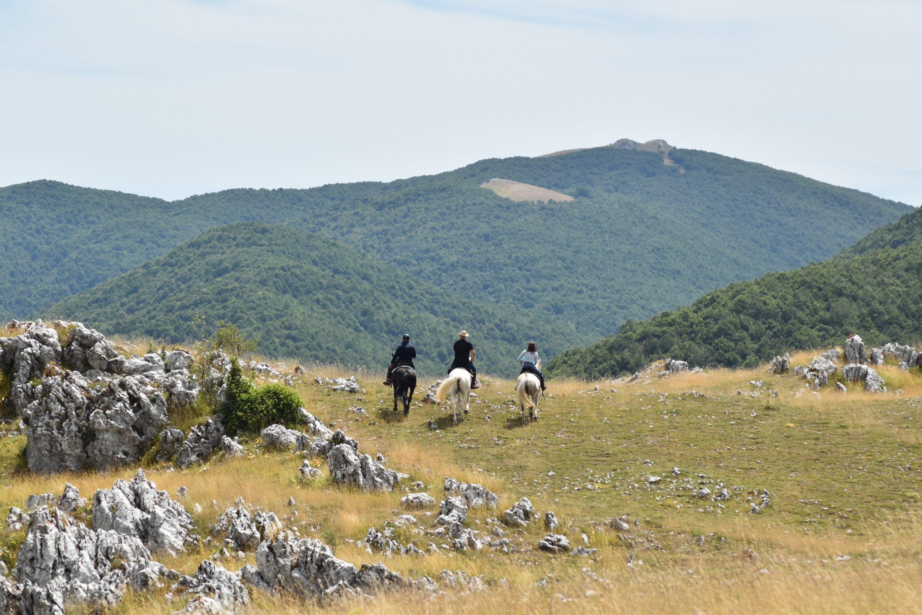 Persone a cavallo con sullo sfondo il Monte Autore.
